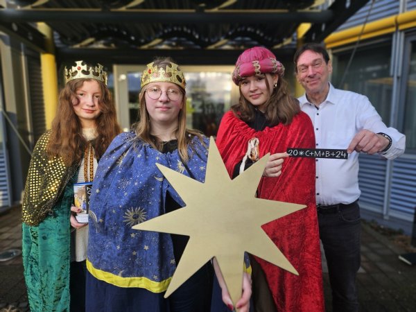Kathi Erichsmeier (14, von links), ihre Schwester Lissi Erichsmeier (15) und Charlotte Conring (14) sind zu Gast im Medien Centrum Giesdorf. Alexander Riedel von der Giesdorf Mediengruppe übergibt den Sternensingern im Namen der Geschäftsführung eine Spende. - © Janet König
