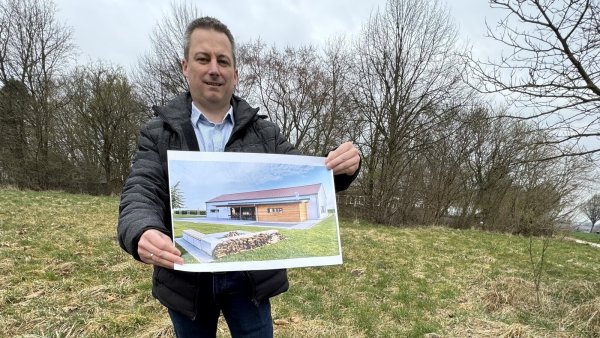 Nicolai Trettin zeigt das Bild eines Gebäudes auf dem Areal in der Nähe der AWO-Kita. Das Foto ist aber lediglich zur Illustration gedacht, wie ein Dorfgemeinschaftshaus einmal aussehen werde, müsse sich zeigen. - © Sven Kienscherf