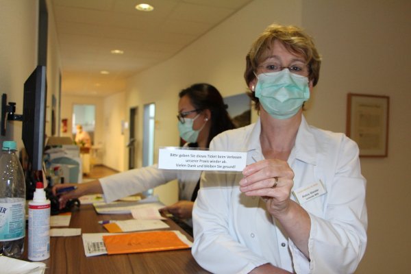 Die Medizinische Fachangestellte Petra Giesler leitet das Team in der Gemeinschaftspraxis von Dr. Hans-Christian Körner. Sie zeigt das Kärtchen, das die Patienten am Ausgang abgeben müssen. Ihre Kollegin Doan Cao koordiniert die Besetzung der Wartezimmer. - © Astrid Sewing