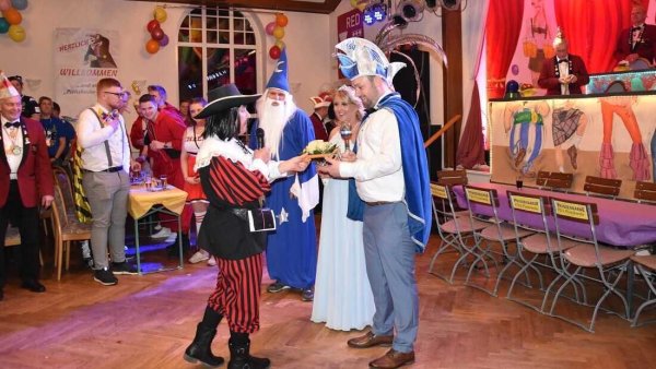 Angelika Kasten, damals stellvertretende Bürgermeisterin von Detmold, überreicht ein "Flachgeschenk" an das Prinzenpaar. - © Bildrechte: Angelika Kasten