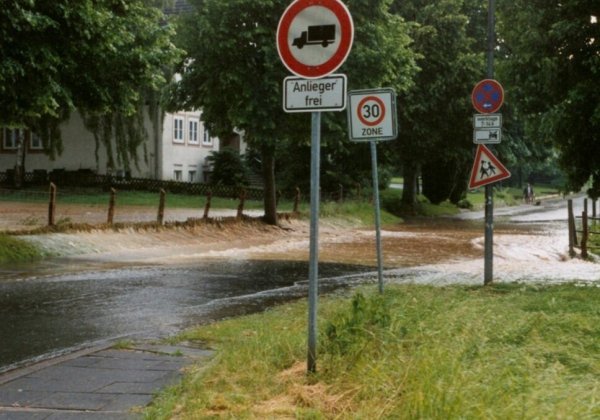 Wenn es stärker regnet, dann fließt das Wasser in Strömen über die Straße vor der Grundschule. Die SPD hat deshalb große Bedenken, wenn hier gebaut wird. - © Frank Drexhage
