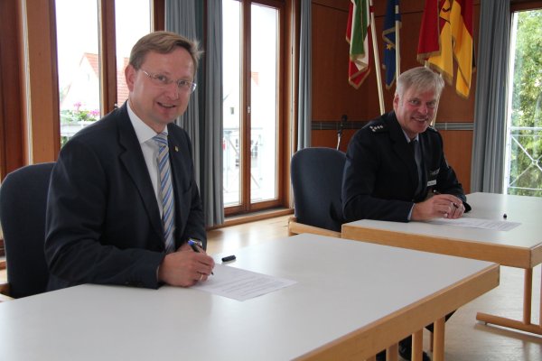 Bürgermeister Dr. Andreas Wulf (links) und Dr. Matthias Wendtland, Leiter der Polizeiwache Detmold, unterzeichnen die Ordnungspartnerschaft. - © Nadine Uphoff