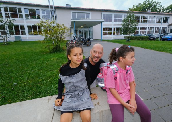 Ein täglicher Kampf: Fatih Dogan mit Tochter Kayla (6, l.) und Mitschülerin Mislina (6) vor der Hans-Christian-Andersen-Schule. - © Andreas Zobe