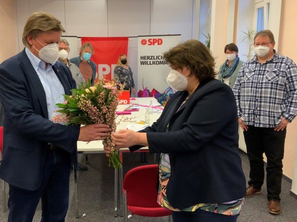 Kreisvorsitzende Ellen Stock gratuliert Jürgen Berghahn mit Blumen. - © SPD