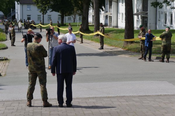 Brigadegeneral Marco Eggert und der Augustdorfer Bürgermeister Thomas Katzer beobachten, wie das vom Kasernentor kommende gelbe Band mit Unterstützungsbekundungen langsam die gemeinsame Heimgesellschaft erreicht. - © Jost Wolf