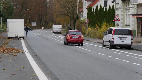 Wer darf wo parken und fahren? Nach der neuen Markierung der Blomberger Straße sind die Park-Regeln den Anwohnern offenbar unklar. Der Verkaufswagen links steht auf dem (noch nicht gekennzeichneten) Radweg und blockiert damit den Weg des E-Scooter-Fahrers. Der Wohnwagen rechts im Hintergrund steht auch auf dem Radweg. Der weiße Lieferwagen parkt korrekt. Das rote Auto müsste links vom Angebotsstreifen fahren. - © Jost Wolf