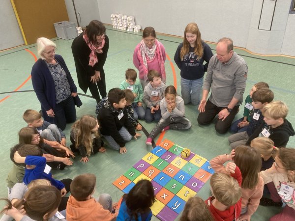 Claudia Holle (von links), Sabine Tewes-Wittig, Klassenlehrerin Nelly Tepper, Praktikantin Sina Kehde und Reinhard Stükerjürgen lernen mit den Kindern das Programmieren des Bee-Bots. - © Nico Düllmann