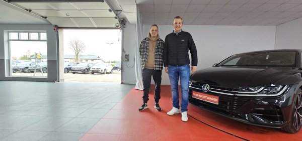 Teamleiter Sebastian Milde und Geschäftsführer Christoph Stricker stehen neben dem Drehteller der neuen Fahrzeugaufbereitung, mit dem die Gebrauchtwagen fürs Internet automatisiert fotografiert werden können. - © Jost Wolf
