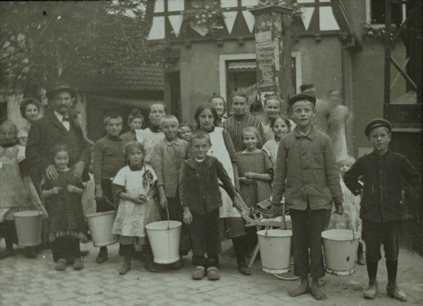 Oerlinghauser Kinder um 1911. Das frühe Bild aus der Gemeinde zeigt die Gruppe an der Dorfpumpe am Ende der Hauptstraße, dort wo die Niedernstraße rechts abbiegt. - © Repros: Horst Biere / Quelle: Stadtarchiv