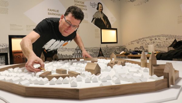 Ulrich Haselhuhn nimmt beim Aufbau letzte Handgriffe am Stadtmodell in der stadtgeschichtlichen Dauerausstellung in der Wandelhalle vor. Dieser sogenannte Medientisch soll in Zukunft attraktiver werden, beispielsweise durch Projektionen. - © Alexandra Schaller