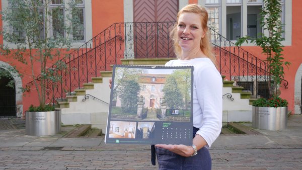 Geschäftsführerin der Arbeitsgemeinschaft Historische Stadt- und Ortskerne NRW Berit Weber, Abteilungsleiterin der Lemgoer Stadtplanung, präsentiert den Denkmal-Kalender für 2025. - © Alte Hansestadt Lemgo