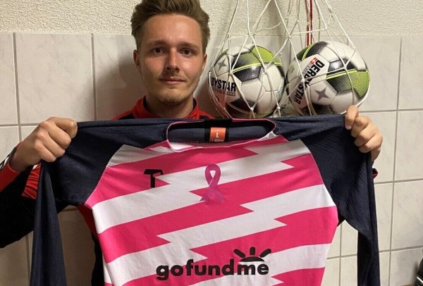Das pink-weiße Trikot mit der Schleife, die auf Brustkrebs aufmerksam macht, hält Luc William Brunton in der Kabine des VfL in die Kamera. - © Sebastian Lucas