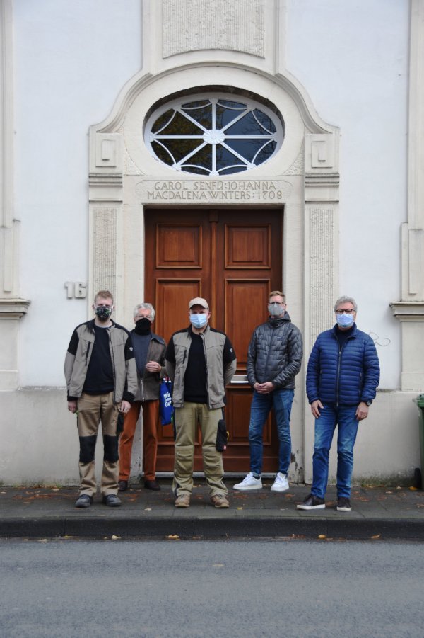 Garret Solle (Baudenkmalpflege Wahl), Clemens Heuger (Freunde der Residenz), Johannes Wahl (Baudenkmalpflege Wahl), Jochen Brockbals und Helmut Merwitz (beide Freunde der Residenz, von links) haben die Sanierung des Ovalfensters in der Neustadt 16 in die Tat umgesetzt. - © Raphael Bartling