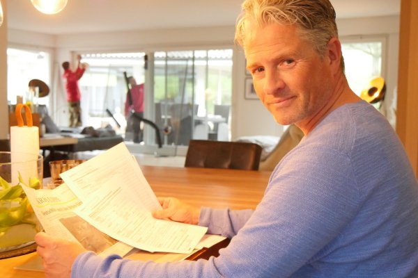 Gunnar Altenfeld mit dem Schadensersatzantrag und dem LZ-Artikel, der ihn auf Möglichkeit der Manöverschadensregulierung hinwies. Im Hintergrund tauschen die Fensterbauer Carsten Pape und Sebastian Leszczynski die Scheibe, auf der die Risse notdürftig mit Klebeband gesichert sind. - © Jost Wolf