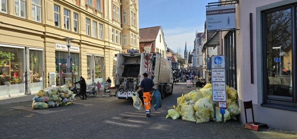 Der gelbe Müll bleibt mitunter bis zum frühen Nachmittag in der Fußgängerzone liegen. Im Hintergrund herrscht reger Publikumsverkehr. - © Jost Wolf