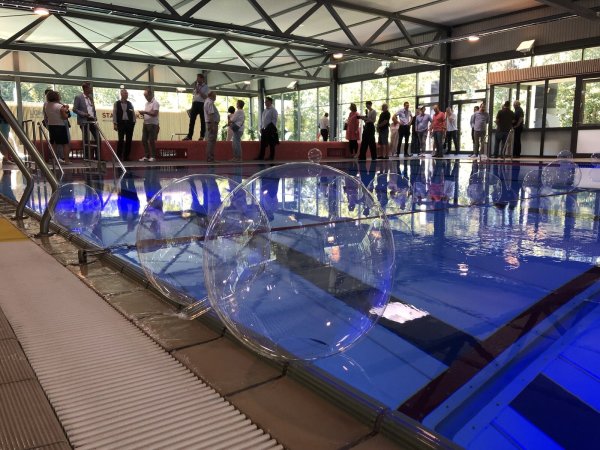 Die geladenen Gäste schauen sich das rundsanierte Hallenbad an. Im Vordergrund das Schwimmerbecken mit dem Hubboden. - © Thomas Reineke
