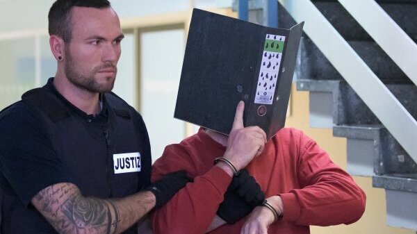 Der 58-jährige Angeklagte aus Blomberg (rechts) wird im Juli 2019 im Landgericht Freiburg von Justizbeamten zum Gerichtssaal gebracht. - © Silas Stein/dpa