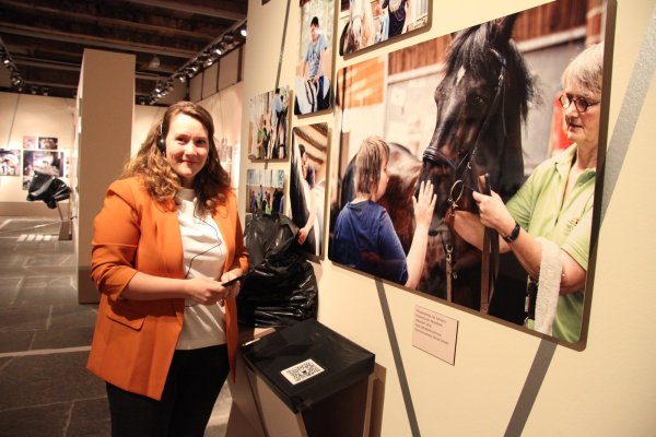 Audio-Guides dürfen wegen der Hygienevorschriften zwar nicht an Besucher ausgehändigt werden, über QR-Codes lässt sich das Hörbuch zur Ausstellung aber mit dem eigenen Smartphone aufrufen. Ausstellungskuratorin Janina Raub macht es vor. - © Kirsten Fuhrmann