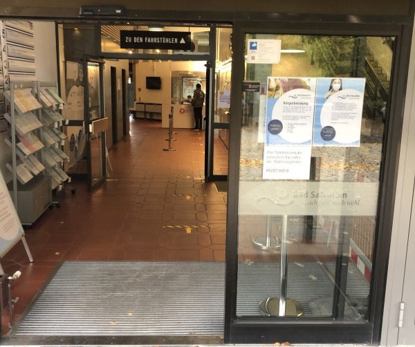 Der einzige öffentlich zugängliche Eingang ins Rathaus an der Rudolph-Brandes-Allee: Die Pfeile auf dem Boden weisen direkt zu dem kleinen Empfangstisch mit Spuckschutz im Hintergrund, an dem ein Mitarbeiter einer privaten Sicherheitsfirma jeden Besucher begrüßt und nach seinem Termin fragt. - © Thomas Reineke