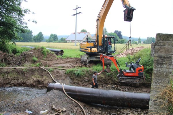 Die Arbeiten an der Bruchsteinmauer-Brücke sind in den letzten Zügen. Ein kleiner Bagger wird ins Bachbett gehievt, um kleine Steine zu entfernen. An deren Stelle rücken größere, die verhindern sollen, dass das Fundament erneut Schaden nimmt. - © Kirsten Fuhrmann(LZ)