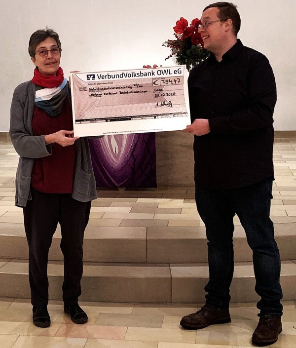 Pfarrerin Renate Kersten übergibt in der Kirche am Sedanplatz die Spende an Fabian Schmidt von der Bahnhofsmission. - © Fotorechte: Lutherische Kirchengemeinde
