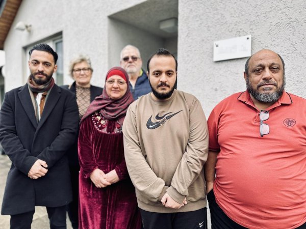 Hisham Abdulzaraq (l.) mit Eltern und Bruder vor dem Haus der Busses (hinten), in dem sie seit acht Jahre wohnen. - © Stefan Becker