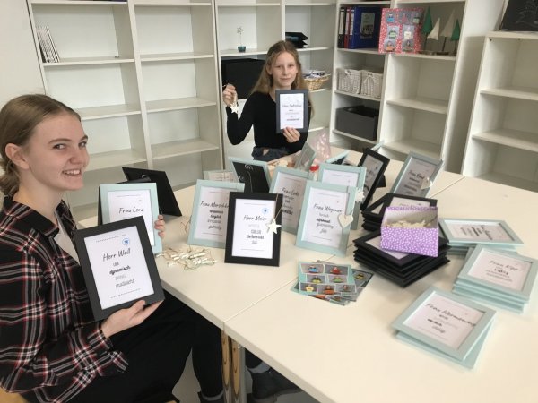 Paula Peters (links) und Iliana Warkentin zeigen die Geschenke für die Lehrer. - © Edith Kemeny
