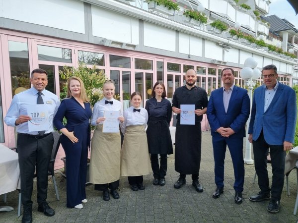 Freuen sich über die erneute Auszeichnung als Top-Ausbildungsbetrieb durch Verbandsgeschäftsführer Kai Buhrke (rechts): Inhaberin Swetlana Lenger (2 von links) und Inhaber Matthias Lenger (2. von rechts) mit Restaurantleiter Ali Kaplan (links) und vier Auszubildende des Kurparkhotels. - © Dehoga