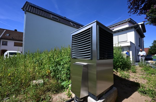 Vor einem neu gebauten Wohngebäude ist im Garten eine Wärmepumpe zum Heizen des Gebäudes installiert. - © Bernd Weißbrod/dpa