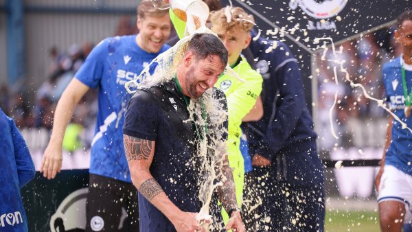 Volltreffer: Arminia-Keeper Jonas Kersken verpasst seinem Trainer Mitch Kniat eine Bierdusche. - © Oliver Krato