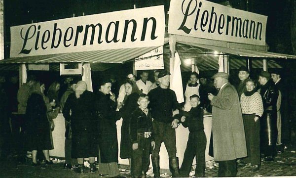 Historisches Foto aus den 1950er Jahren: Diese Besucher hatten offenbar Hunger und besuchten deshalb auf Wilbasen den Stand der Rossschlachterei Liebermann aus Detmold. - © Archiv