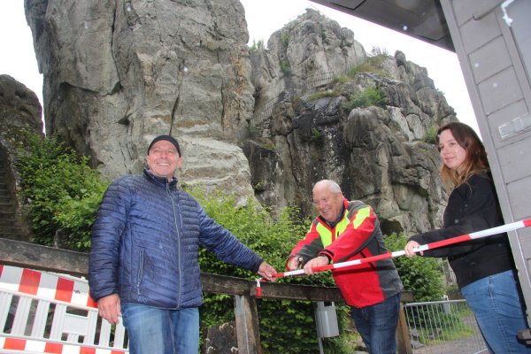 Ralf Noske (links), Peter Gröne, Geschäftsführer der Denkmal-Stiftung, und Stefanie Hütte, Leiterin der Info-Zentren an Externsteinen und Hermannsdenkmal, öffnen die Sperre.  - © Martin Hostert