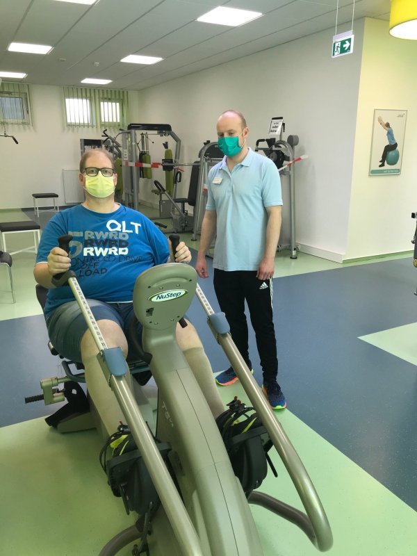 Einsames Vergnügen: In gebührendem Abstand von Therapeut Dominic Schweißhelm unterstützt, dreht Patient Wilfried Volmer seine Runden auf dem Ergometer in der Rose-Klinik. - © Rose-Klinik