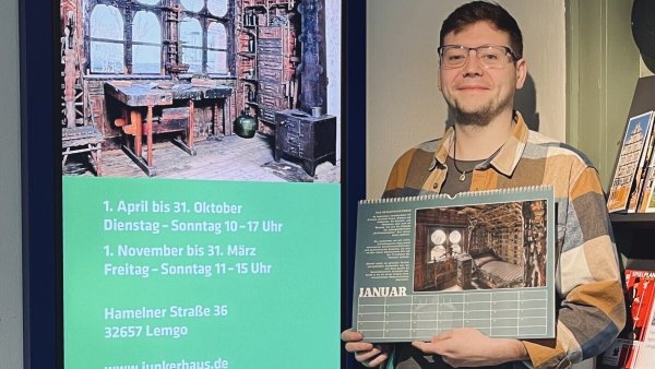 Simon Bucher von den Städtischen Museen Lemgo präsentiert den neuen Kalender mit Motiven des Junkerhauses. - © Stadt Lemgo