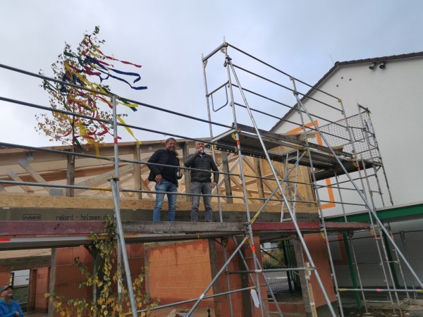 Der Richtkranz weht über dem neuen Stadtteiltreff. Maurermeister Marcus Meier (links) spricht den traditionellen Richtspruch für Bürgermeister und Bauherr Frank Meier. - © Sylvia Frevert(LZ)