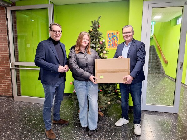 Marc Thiel (links, Geschäftsführung Lippe Bildung eG) und Thomas Mahlmann (zdi-Zentrum
Lippe.MINT) übergeben Mila Hauser den Hauptpreis. - © Lippe Bildung eG