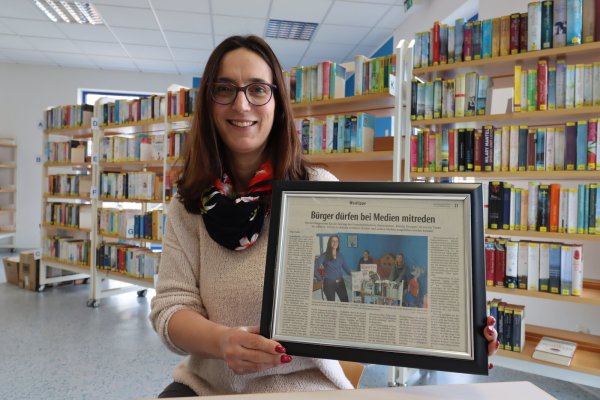 Nach mehr als 20 Jahren Tätigkeit in der Gemeindebücherei, in den vergangenen fast vier Jahren als Leiterin, verlässt Kerstin Koppmann Leopoldshöhe und zieht nach Bayern. Den gerahmten Artikel aus der Zeitung hatte ihr eine Büchereinutzerin 2021 geschenkt. Es war einer ihrer ersten Pressetermine in der Leitungsfunktion – und der Start zu neuen Angeboten und Projekten in der Bücherei. - © Birgit Guhlke