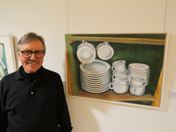 Vernissage der Ausstellug "Zwei Brüder": Joachim Tatje steht vor seinem Bild "Nicht alle Tassen im Schrank" aus dem Jahr 2022. - © Thomas Krügler