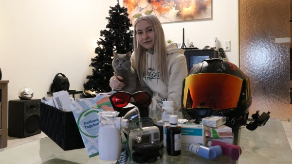 Louisa Heise mit Kater "Bronko" - der Motorradhelm steht für das klein wenig Freiheit, das sie ab und an im Sommer hatte. Täglich schluckt sie unzählige Medikamente wegen ihrer Post-Covid-Erkrankung. - © Alexandra Schaller