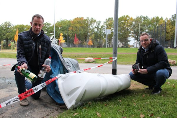 Klaus Hansen und Frederik Topp (von links) ist der Unrat am Bürgerpark ein Dorn im Auge. Die Reste eines jüngst in Flammen aufgegangenen Dixie-Klos zeugen von Vandalismus. - © Sandra Castrup