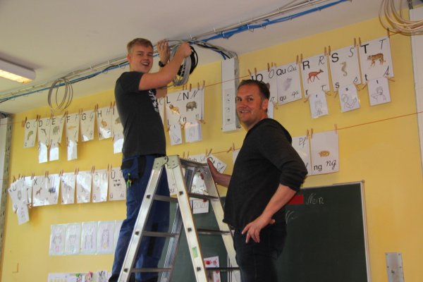 Machen die Grundschule fit fürs schnelle Internet. Louis Rehm (links) und Michael Pramschüfer von der Gebäudewirtschaft ziehen an der Grundschule Kirchheide die Kabel. - © Katrin Kantelberg(LZ)