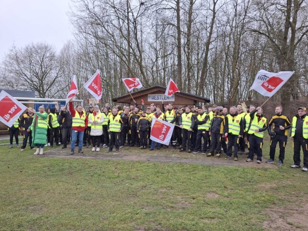 Vor dem Lemgoer Streiklokal posieren die Mitarbeiter mit Flaggen und Warnwesten. - © Ver.di/ Stephan Krüger