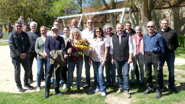 Der neue Vorsitzende des Heimatvereins, Andreas Liske (hinten Mitte), seine Vorgängerin Annette Flörkemeier (mit Blumenstraß) und Bürgermeister Mario Hecker (5. von rechts) freuen sich mit vielen Bürgern über die Eröffnung des Spielplatzes. - © Rudi Rudolph