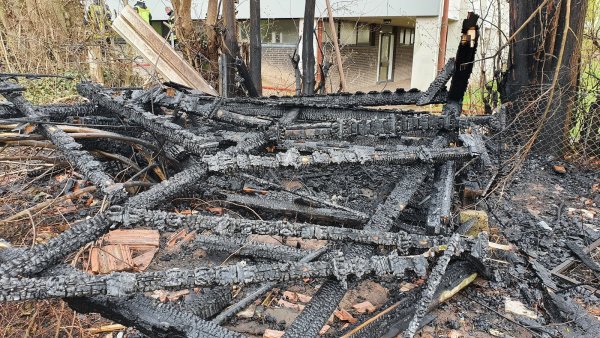 Verkohlte Holzreste zeigen, wo einst die Gartenhütte neben der Grundschule stand. Sie stand voll in Flammen und war nicht mehr zu retten. - © Feuerwehr Barntrup