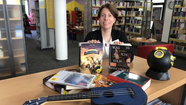 Büchereileiterin Sarah Zimmert mit Medien, die entliehen werden können. Dazu zählen auch eine Ukulele und ein Kinder-Planetarium aus der "Bibliothek der Dinge". - © Sven Kienscherf