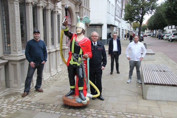 Der Feuerwehr-Hermann weist auf die Sonderausstellung hin. Mit im Bild: (von links) Jan Pieniak von der Hochschule, Klaus Wegener (Leiter der Feuerwehr), Markus Baier (designierter Bürgermeister) und Museumsleiter Fabian Schröder. - © Kirsten Fuhrmann