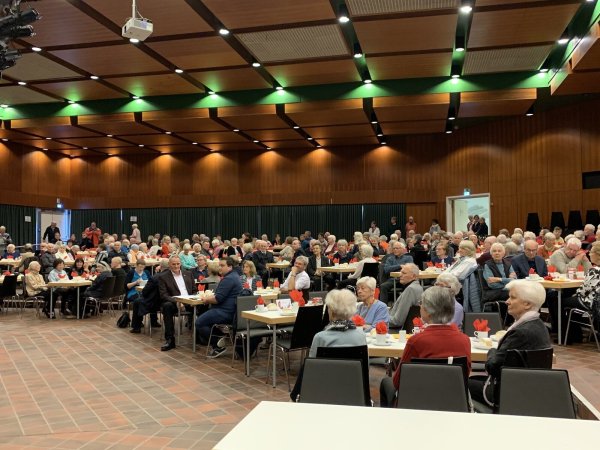 Die Tische in der Aula des Niklas-Luhmann-Gymnasiums waren zur Weihnachtsfeier gut besetzt. Foto: DRK - © DRK