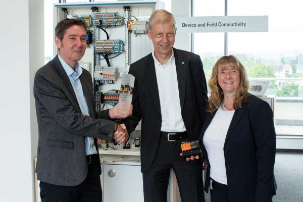 Jürgen Wirtz, Chefredakteur der Fachzeitschrift Schaltschrankbau, übergibt den Schaltschrankbau Innovation Award an Thomas Peter, Leiter der Business Unit Digital Signaling & Protection bei Weidmüller, und Silke Lödige, Produktmanagerin Überspannungsschutz bei Weidmüller (von links). - © Bildrechte: Weidmüller