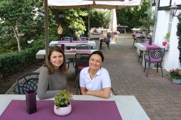 Stefania Bizimi (links) sitzt mit ihrer Schwester Georgiana Bizimi auf der großen Terrasse des Lokals "Zum Salzsieder". - © Alexandra Schaller