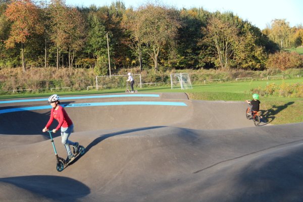 Kinder fahren mit ihren Rollern und Rädern auf dem neuen Pumptrack an der Westalm. - © Nadine Uphoff